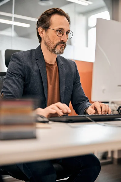 Чоловік офісний працівник дивиться на екран комп'ютера — стокове фото