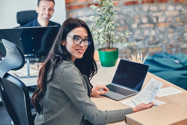 Elegante modelo sonriente utilizar ordenador sentado en la silla en el interior — Foto de Stock