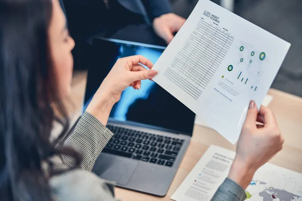 Vrouwelijke hand holding document van de wereldmarkt voor energie onderzoek — Stockfoto