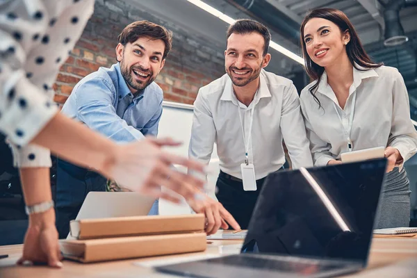 Glückliche Geschäftsleute, die am Schreibtisch miteinander reden — Stockfoto