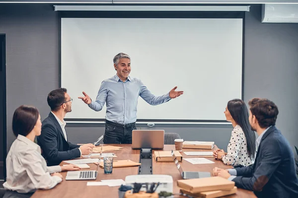 Hombre de negocios adulto dando la bienvenida a su equipo en la reunión — Foto de Stock
