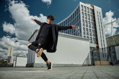 Yakışıklı genç adam sokaklarda numaralar yapıyor.