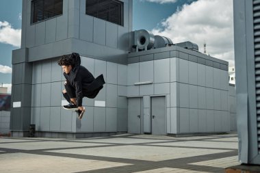 Yakışıklı genç adam sokakta zıplıyor.