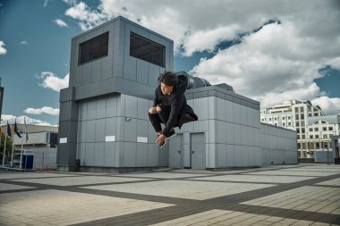 Sokakta hoplayıp zıplayan şık bir delikanlı.