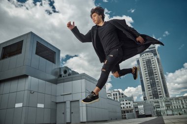 Yakışıklı adam güneşli bir günde havada zıplıyor.