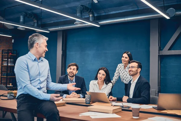 Empleados sentados y celebrando una reunión en una mesa grande — Foto de Stock