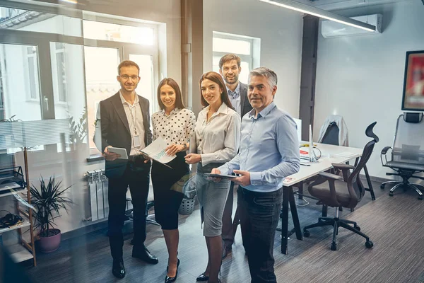 Feliz amable gente inteligente de pie en la oficina interior moderna — Foto de Stock