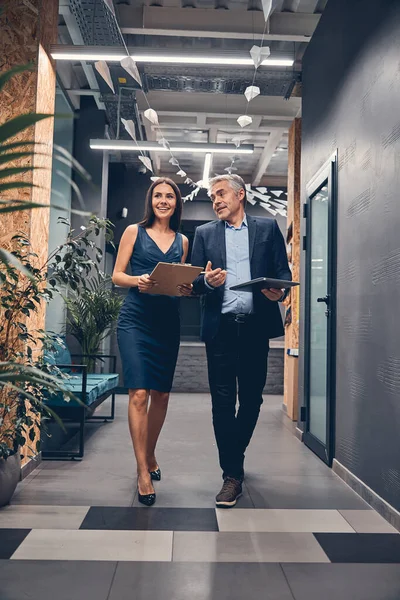 Zelfverzekerde zakenpartner loopt naar beneden in kantoorgebouw en praten — Stockfoto