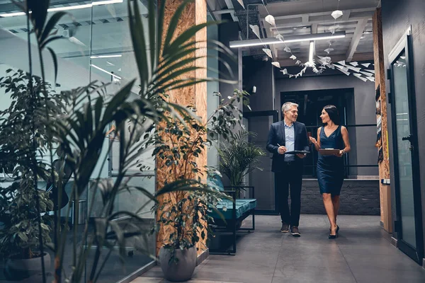 Affärsman och affärskvinna diskuterar arbete när du går — Stockfoto