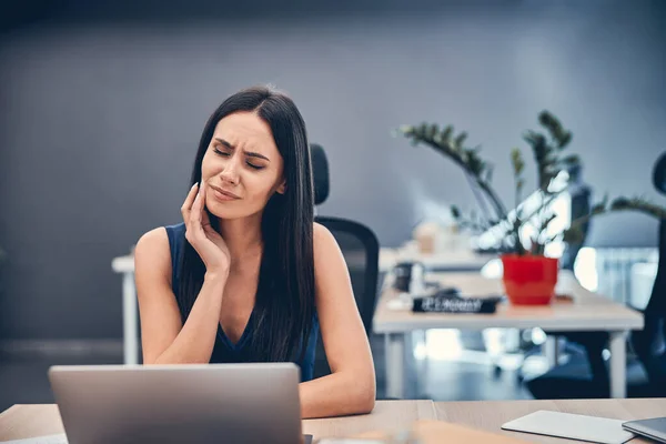 Mujer de negocios alegre que trabaja en el cuaderno en la oficina moderna — Foto de Stock