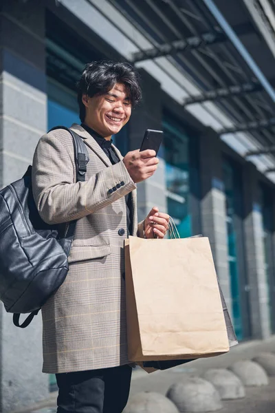 Jovem bonito usando smartphone na rua — Fotografia de Stock