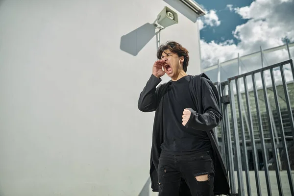 Nyfiken kille i svart outfit skriker utomhus — Stockfoto