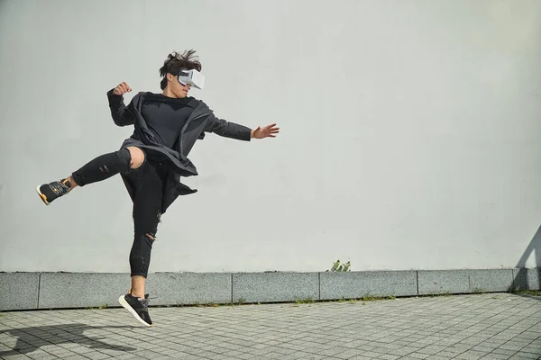 Male fighter using VR headset and jumping in the air — Stock Photo, Image