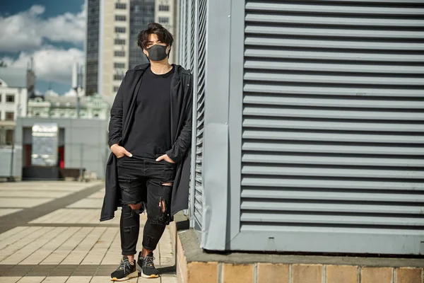 Chico con estilo en máscara facial médica de pie en la calle —  Fotos de Stock