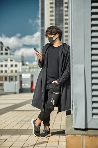 Élégant gars dans le masque médical en utilisant un téléphone portable à l'extérieur — Photo