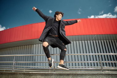 Tasasız genç adam sokakta zıplıyor.