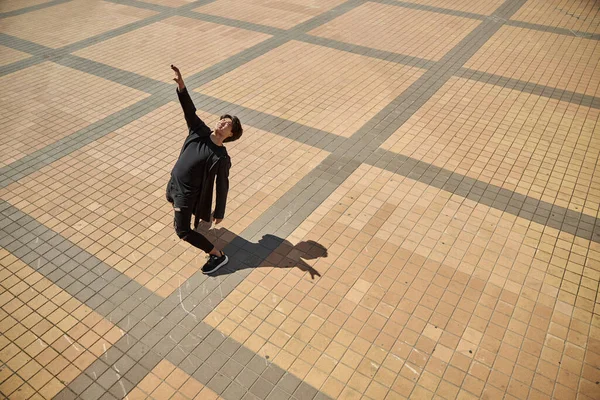 Stylish young man leaning backwards on the street — Stock Photo, Image