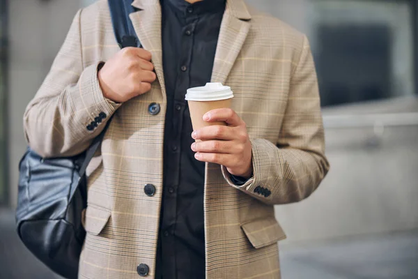Стильный молодой человек держит чашку кофе — стоковое фото