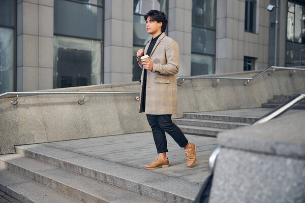 красивый молодой человек, идущий по улице
