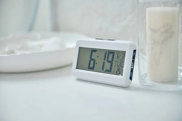 Relógio de alarme eletrônico em interior branco na mesa — Fotografia de Stock