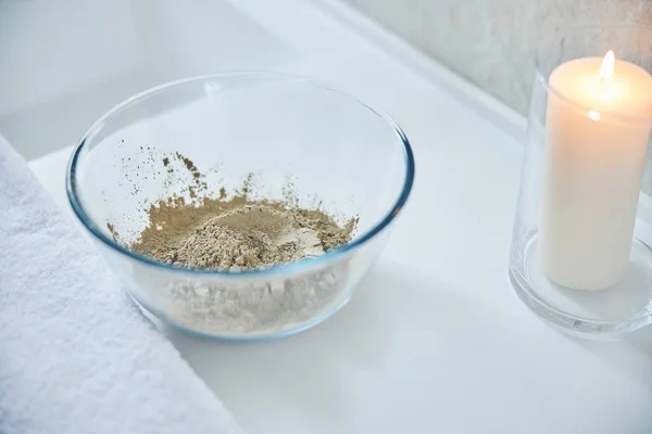 Dry clay powder in glass bowl on white surface — Stock Photo, Image