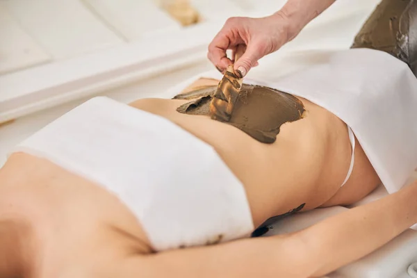 Belly of the woman with body scrub being spread on it — Stock Photo, Image