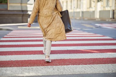 Kadın yaya geçidinde yürüyor.