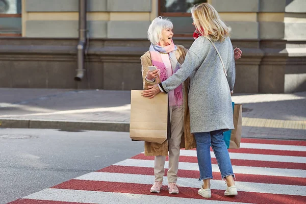 Glückliche Begegnung mit zwei Frauen auf dem Fußgängerüberweg — Stockfoto