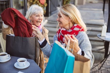 Son sınıf kadınları sokak kafesinde gülüyor.