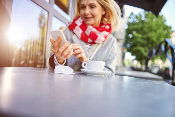 Lächelnde Kaukasierin sieht Foto im Handy — Stockfoto