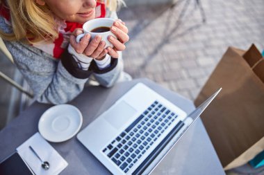 Güzel görünümlü, neşeli bir kadın masada otururken güzel bir günün tadını çıkarıyor.