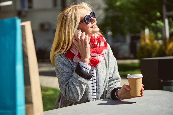 Улыбающаяся блондинка в солнечных очках смотрит на солнце — стоковое фото
