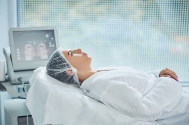 Huzurlu kadın hasta beyaz koğuşta yatıyor.