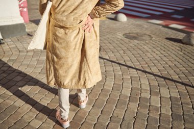 Arkaya bakan olgun bir kadın hafta sonu sokakta yürüyor.