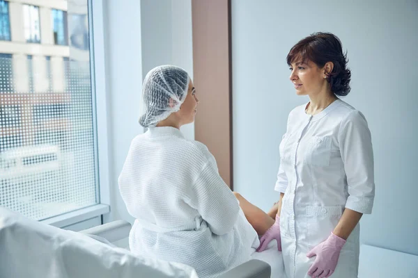 Жіночий пацієнт отримує початкову консультацію в студії краси — стокове фото