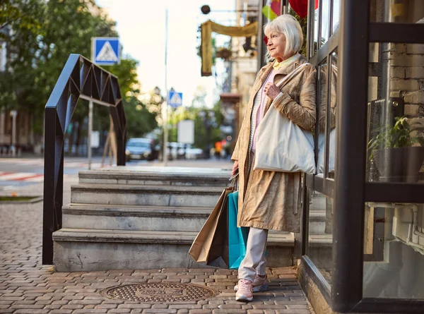 Femeie caucaziană în vârstă care se plimbă pe strada orașului după cumpărături — Fotografie, imagine de stoc