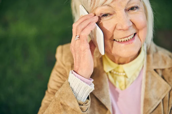 Gut aussehende alte Frau aus dem Kaukasus nimmt Anruf entgegen — Stockfoto