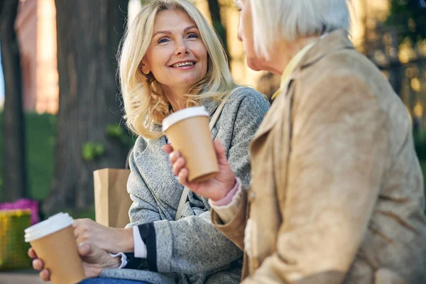 Веселые две взрослые женщины расслабляются, когда пьют кофе — стоковое фото