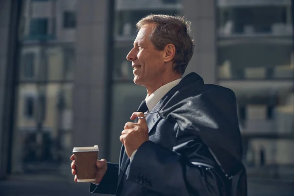 Fröhlicher Mann mit Tasse Kaffee steht auf der Straße — Stockfoto