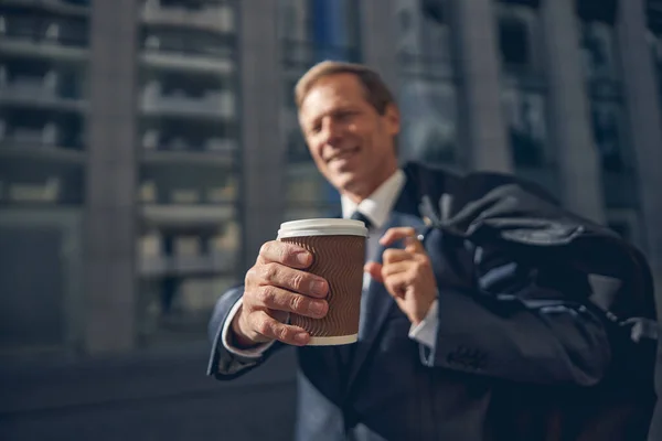 Hombre alegre sosteniendo una taza de café para llevar — Foto de Stock