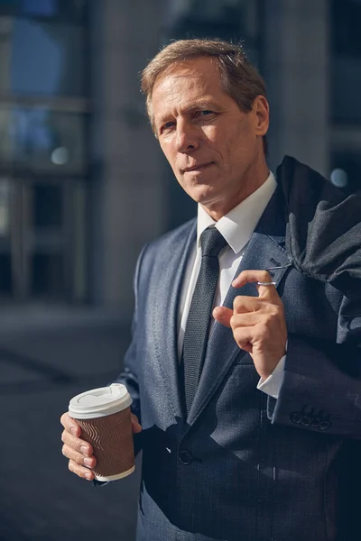 通りに立つためにコーヒーを片手にハンサムな男 — ストック写真