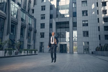 Neşeli yakışıklı adam sokakta zıplıyor