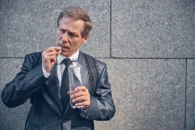 Sokakta hap alan yakışıklı adam.