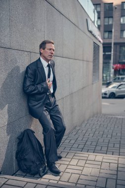Sokaklarda göğüs ağrısı çeken orta yaşlı bir adam.
