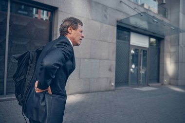 Mutsuz bir adam arka tarafta acı çekiyor.