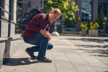 Dışarıda diz ağrısı çeken orta yaşlı bir adam.