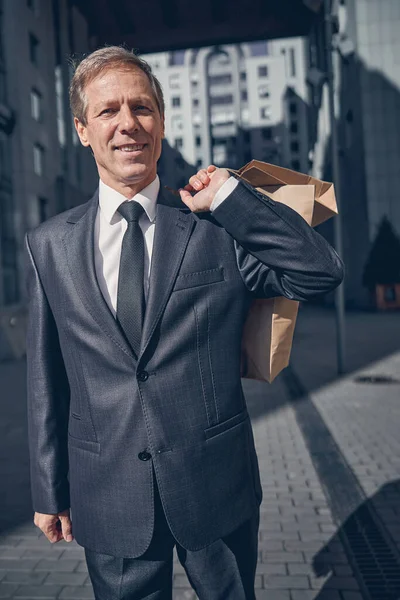 Vreugdevolle man met boodschappentassen op straat — Stockfoto