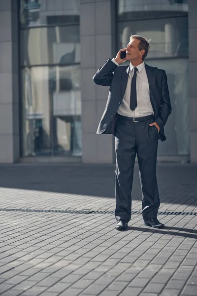 Όμορφος άντρας με κοστούμι να κάνει τηλεφωνική συζήτηση έξω. — Φωτογραφία Αρχείου