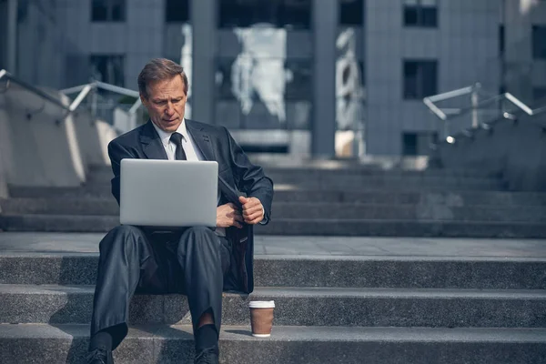 Красивый бизнесмен с ноутбука на улице — стоковое фото