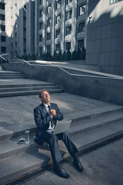 Schöner Mann im Anzug mit Laptop auf der Straße — Stockfoto